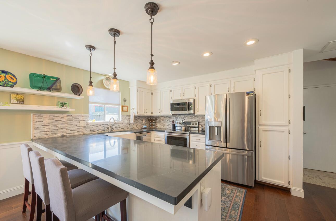 408 Kipling Street Salinas, CA 93901 - Photo 11 of 33 a kitchen with stainless steel appliances granite countertop a sink a stove a refrigerator cabinets and wooden floor