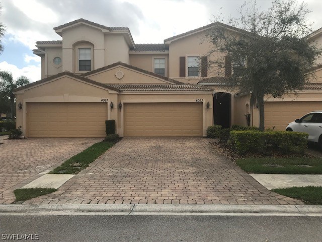 4063 Cherrybrook Loop Fort Myers, FL 33966 - Photo 2 of 15 a front view of a house with a yard and garage