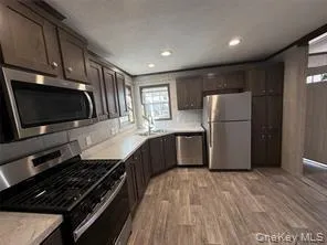 a kitchen with a refrigerator and a stove top oven