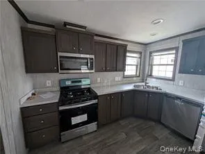 a kitchen with sink a microwave a stove and cabinets