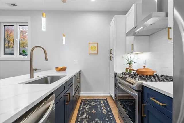 a kitchen with stainless steel appliances granite countertop a sink stove and cabinets