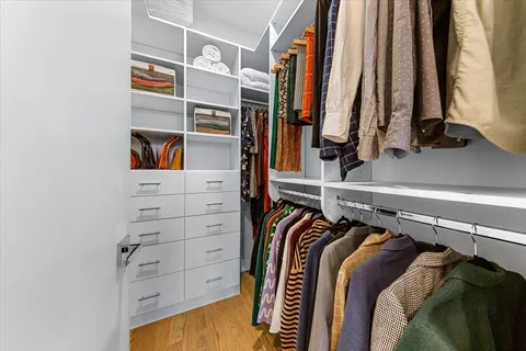 a view of walk in closet with clothes and shoes