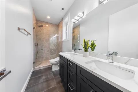 a bathroom with a double vanity sink toilet and shower