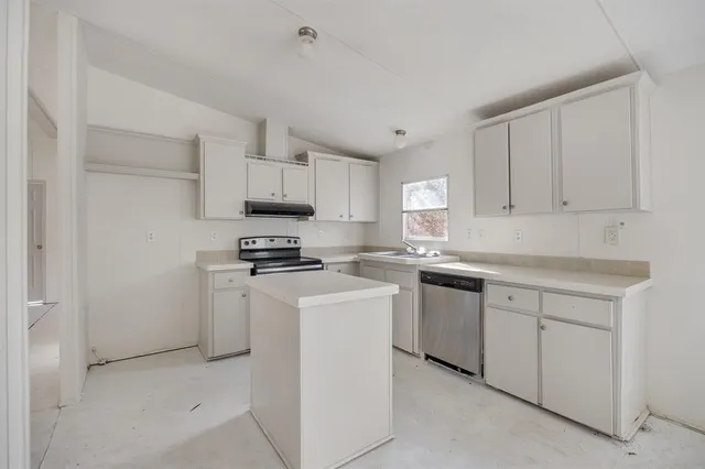 a kitchen with cabinets appliances and a sink