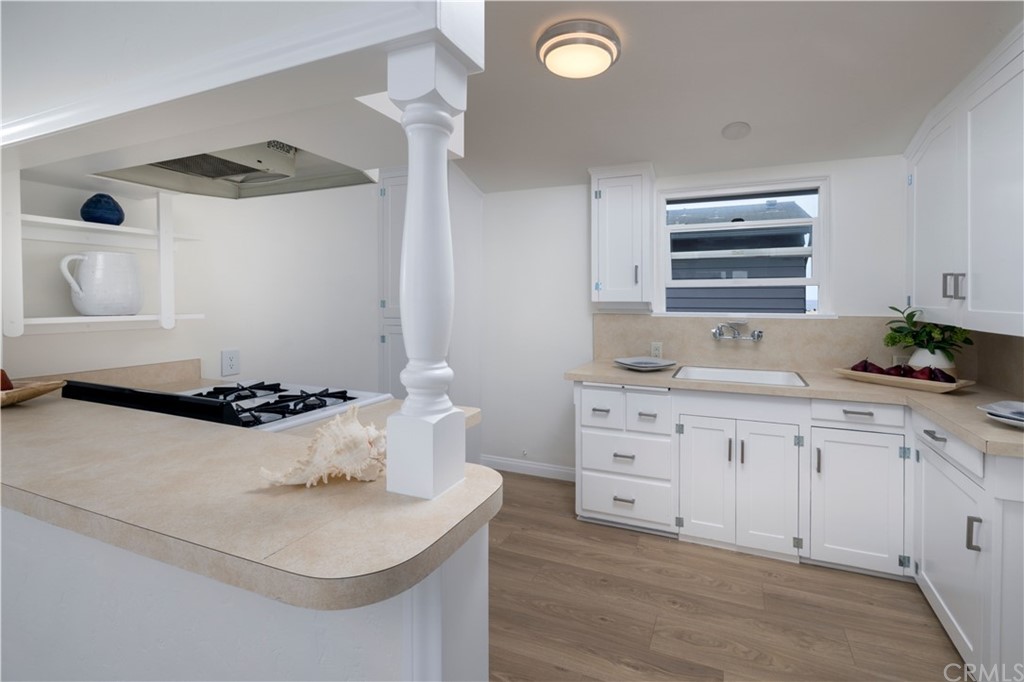 1708 West Oceanfront Newport Beach, CA 92663 - Photo 32 of 43 a kitchen with a sink a stove and cabinets