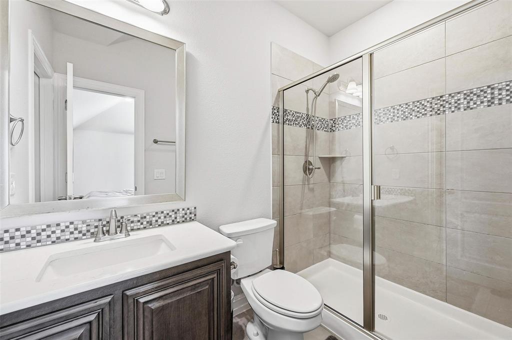 609 Dusty Glen Trail Midlothian, TX 76065 - Photo 26 of 40 a bathroom with a granite countertop sink a toilet and shower