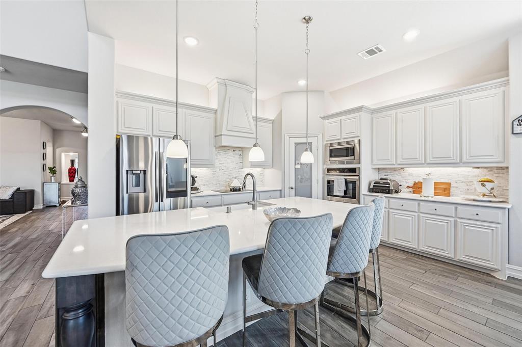 609 Dusty Glen Trail Midlothian, TX 76065 - Photo 10 of 40 a large kitchen with kitchen island a table and chairs