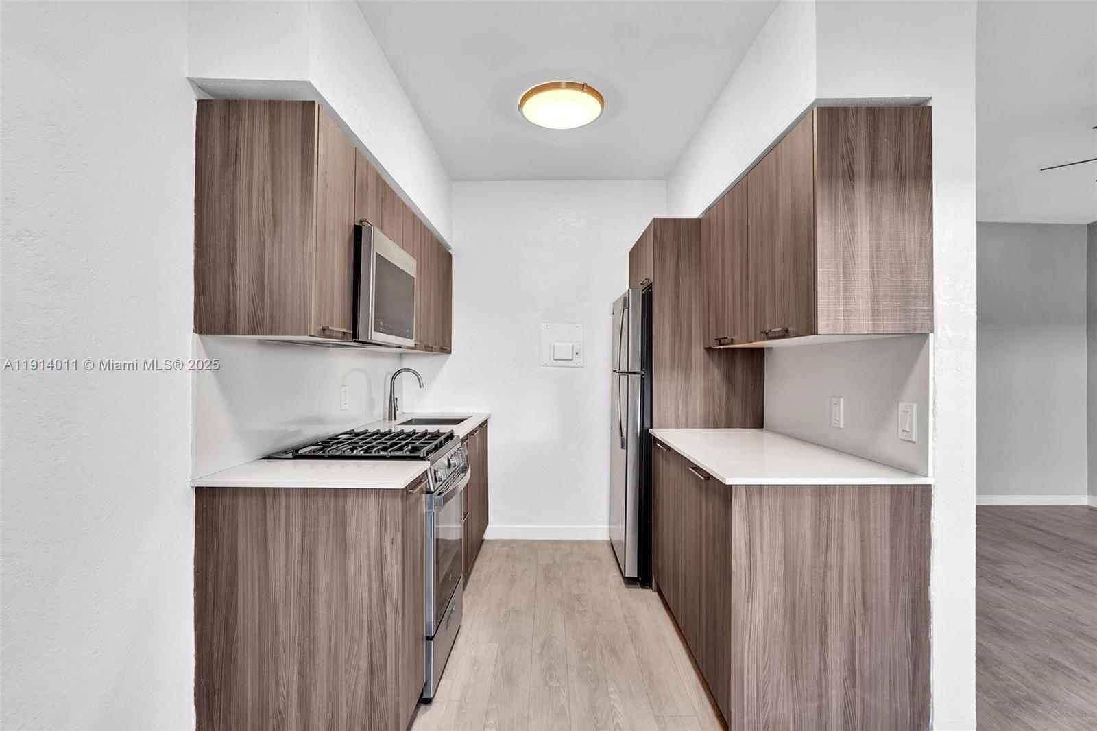 9200 East Bay Harbor Drive, Unit 2A Bay Harbor Islands, FL 33154 - Photo 17 of 45 a kitchen with stainless steel appliances granite countertop a refrigerator stove and wooden cabinets