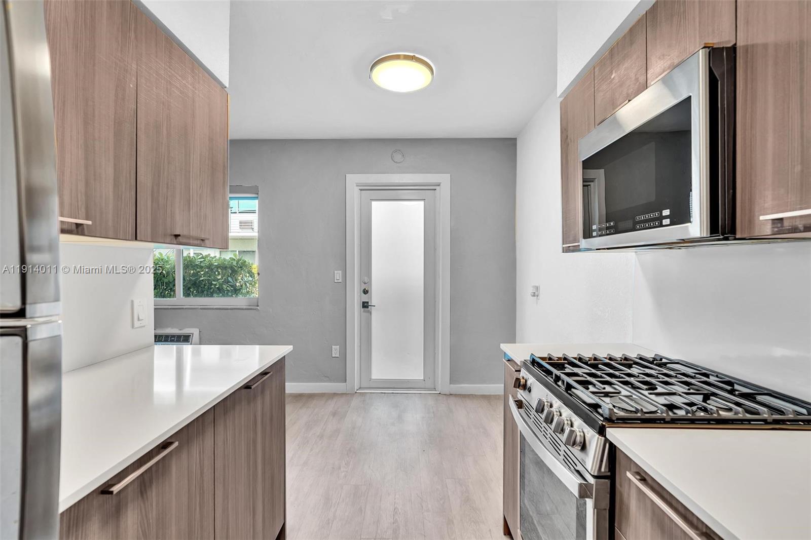9200 East Bay Harbor Drive, Unit 2A Bay Harbor Islands, FL 33154 - Photo 3 of 45 a kitchen with a sink stove top oven and cabinets