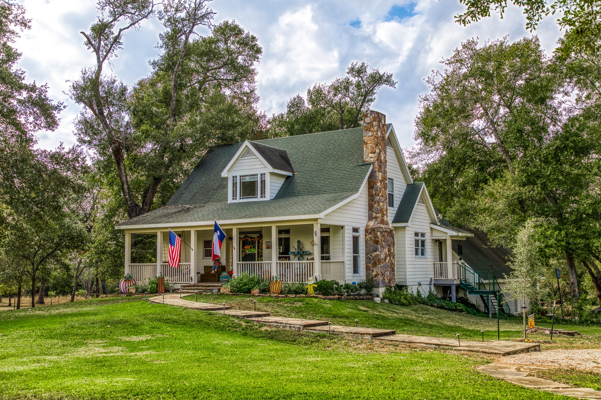 a front view of a house with a garden and trees