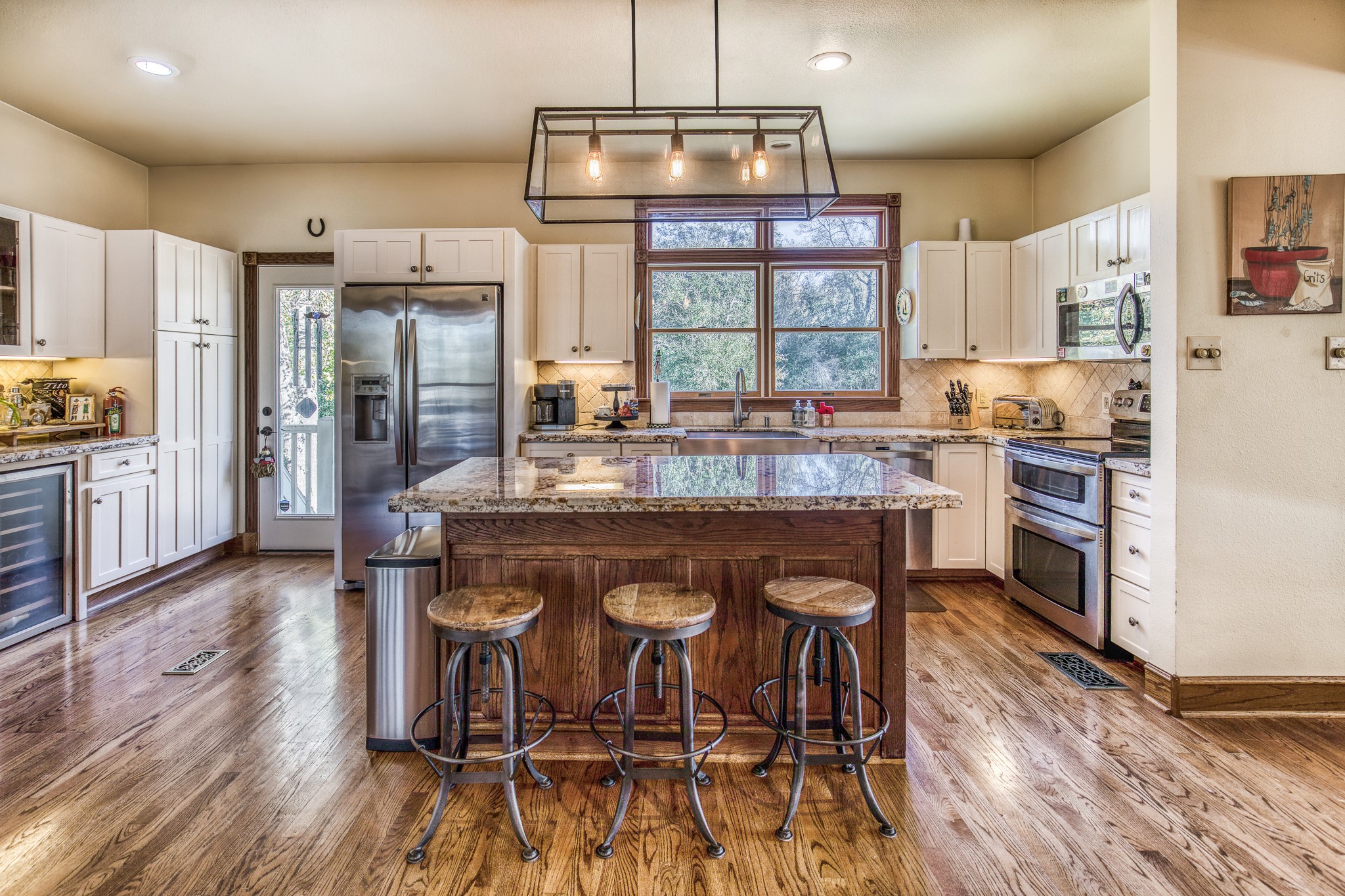 533 Bybee Road Round Top, TX 78954 - Photo 4 of 29 a kitchen with stainless steel appliances a dining table chairs refrigerator and cabinets