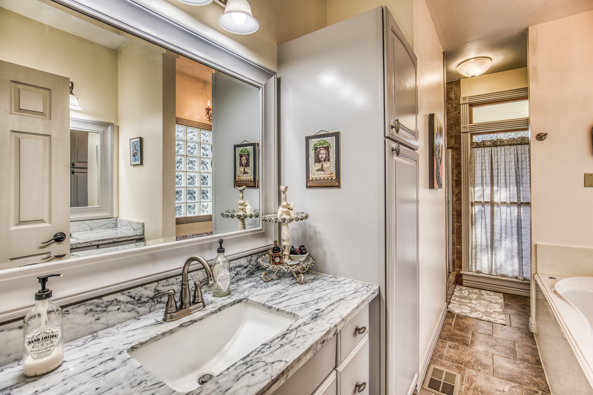 533 Bybee Road Round Top, TX 78954 - Photo 8 of 29 a bathroom with a granite countertop double vanity sink a mirror and a shower