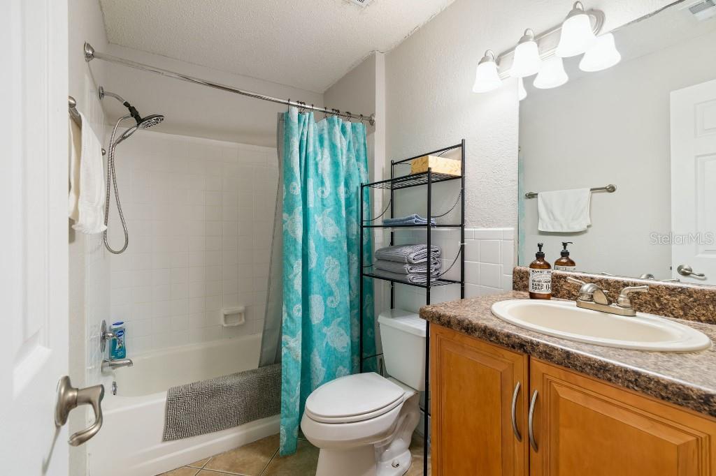 13125 Wilcox Road, Unit 6205 Largo, FL 33774 - Photo 23 of 48 a bathroom with a granite countertop sink a toilet and shower