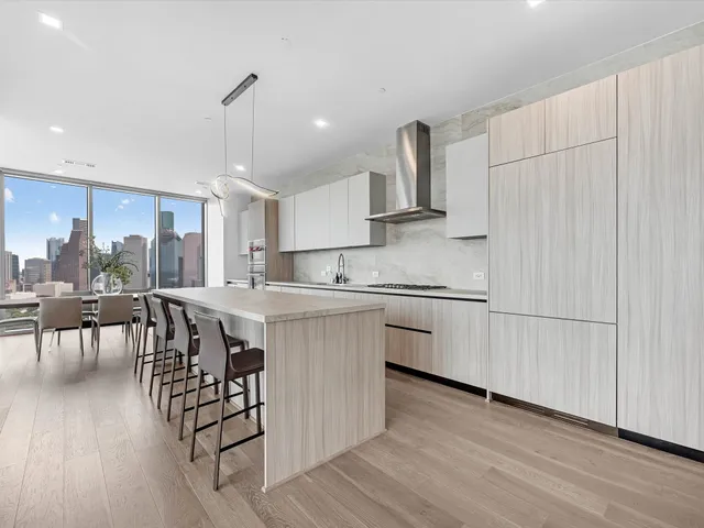 a kitchen with stainless steel appliances granite countertop a white cabinets and wooden floors