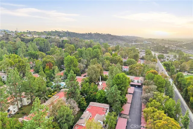 an aerial view of residential house with outdoor space and trees all around