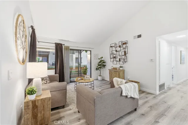 a living room with furniture wooden floor and a large window
