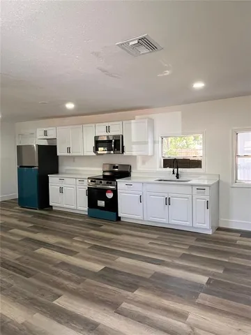 a view of kitchen with microwave and cabinets