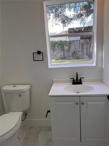 a bathroom with a toilet a sink and a window