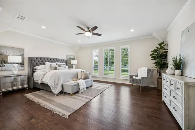 a spacious bedroom with a large bed and a chandelier