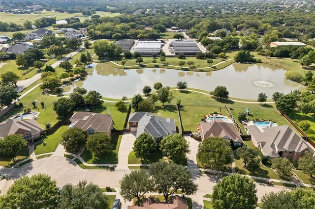 an aerial view of residential houses with outdoor space and lake view