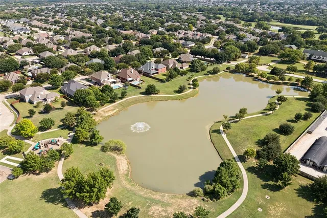 an aerial view of a house with a yard and lake view