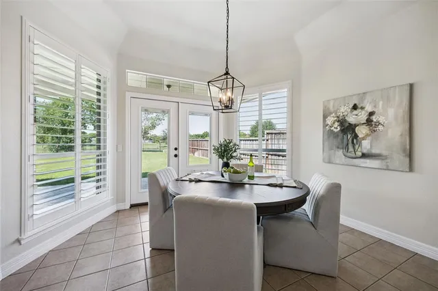 a dining room with furniture a chandelier and wooden floor