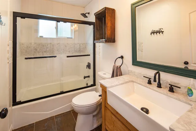 a bathroom with a sink a toilet and shower