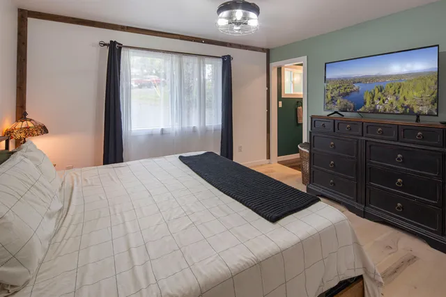 a bedroom with a bed and a large mirror on dresser