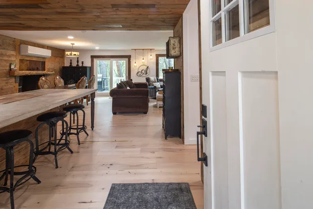 a lobby with furniture wooden floor and a kitchen view