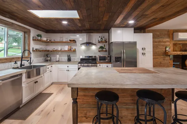 a kitchen with stainless steel appliances granite countertop a sink a stove and a refrigerator