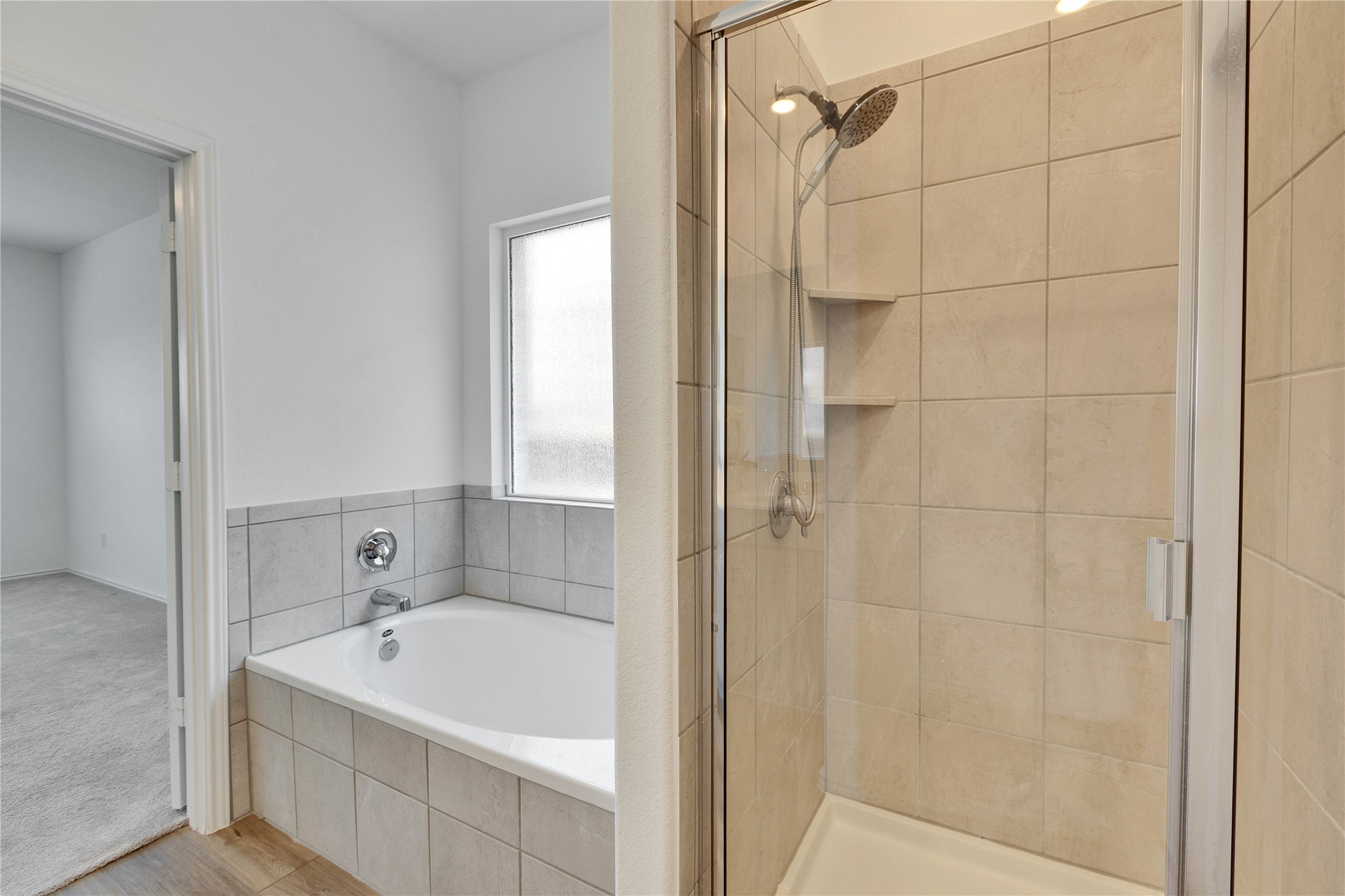 206 Canley Loop Hutto, TX 78634 - Photo 15 of 31 Full bath in primary with a glass stall shower and bathtub.