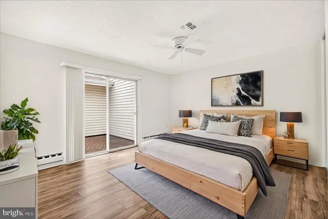a bedroom with a large bed and a potted plant