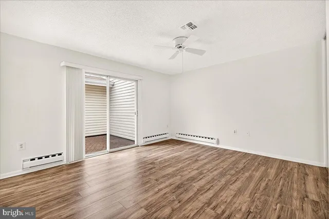 an empty room with wooden floor and window