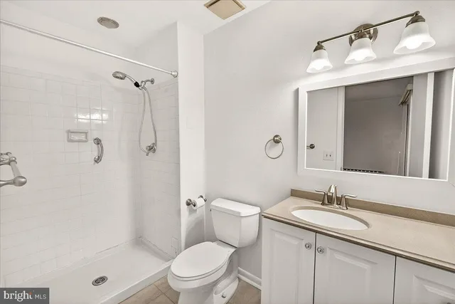 a bathroom with a granite countertop sink a toilet and shower