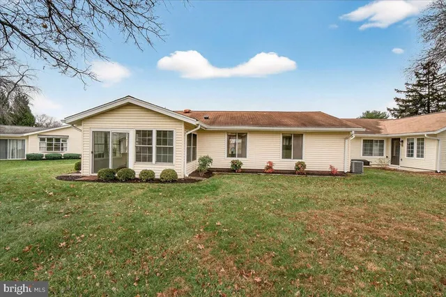 a view of a yard in front of a house with a large tree