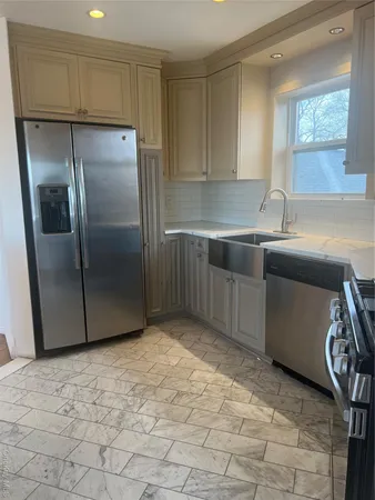 a kitchen with stainless steel appliances granite countertop a sink and a refrigerator
