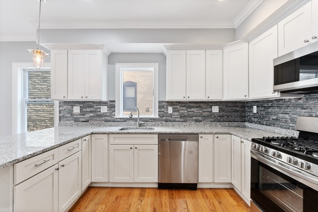9 Wales Street, Unit 2 Boston, MA 02124 - Photo 8 of 15 a kitchen with granite countertop a sink a stove and cabinets