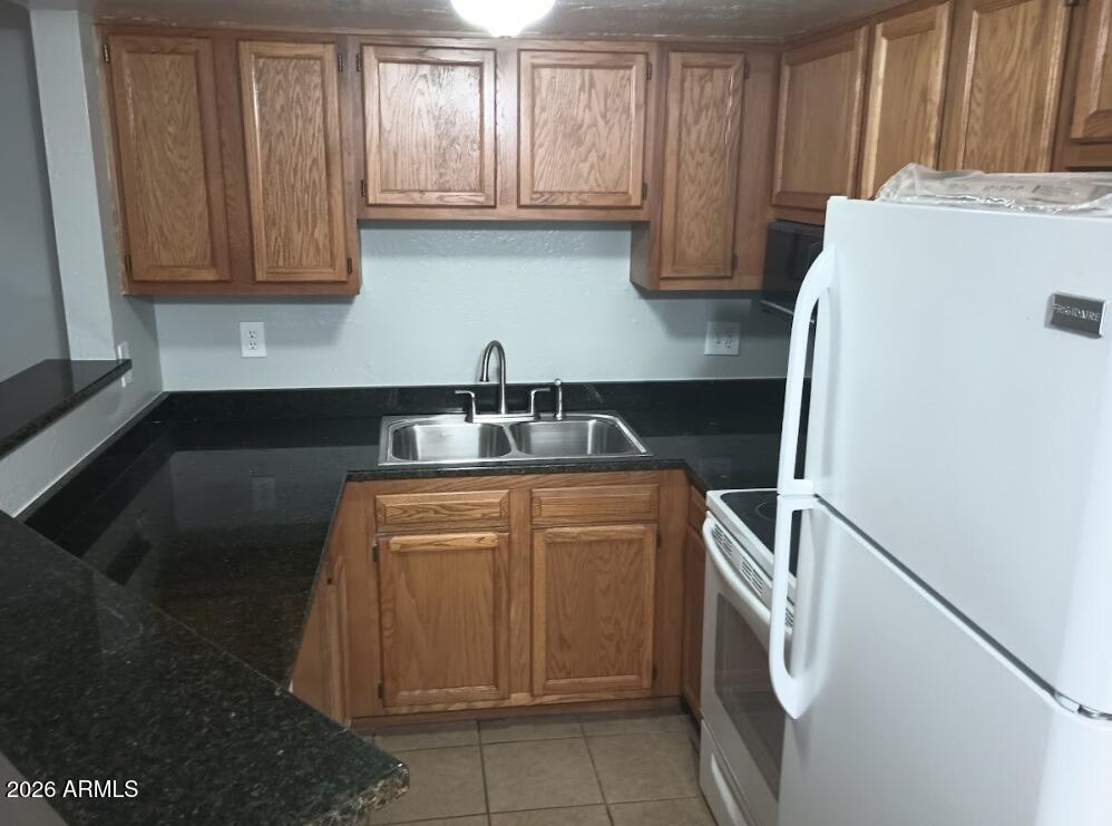12221 West Bell Road, Unit 182 Surprise, AZ 85378 - Photo 3 of 10 a kitchen with stainless steel appliances granite countertop a refrigerator sink and cabinets