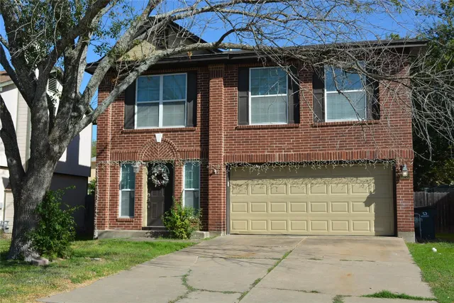 a front view of a house with a garden and garage