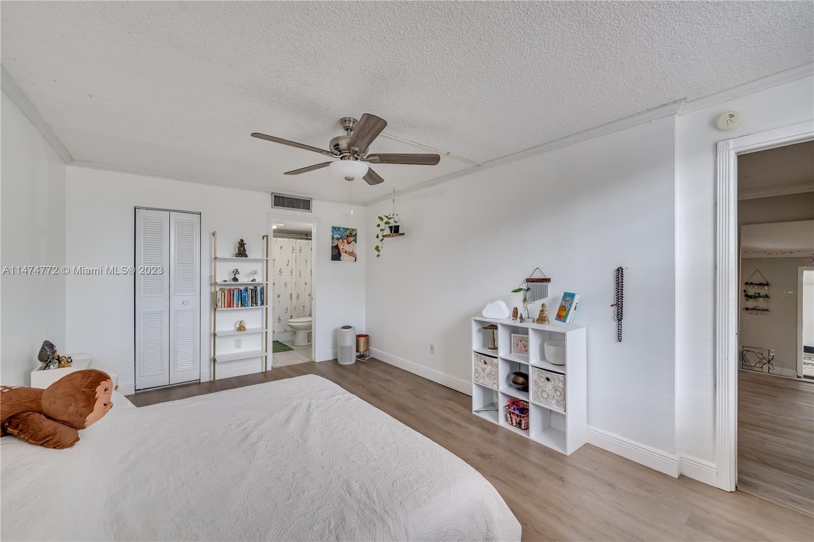 Promenade at Kendale Lakes Condominiums Miami, FL 33186 - Photo 11 of 29 a bedroom with a large bed and a chandelier