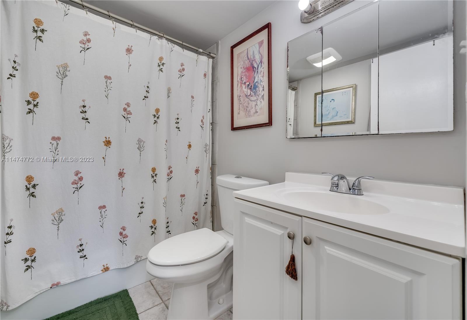 Promenade at Kendale Lakes Condominiums Miami, FL 33186 - Photo 14 of 29 a bathroom with a sink a toilet and a mirror