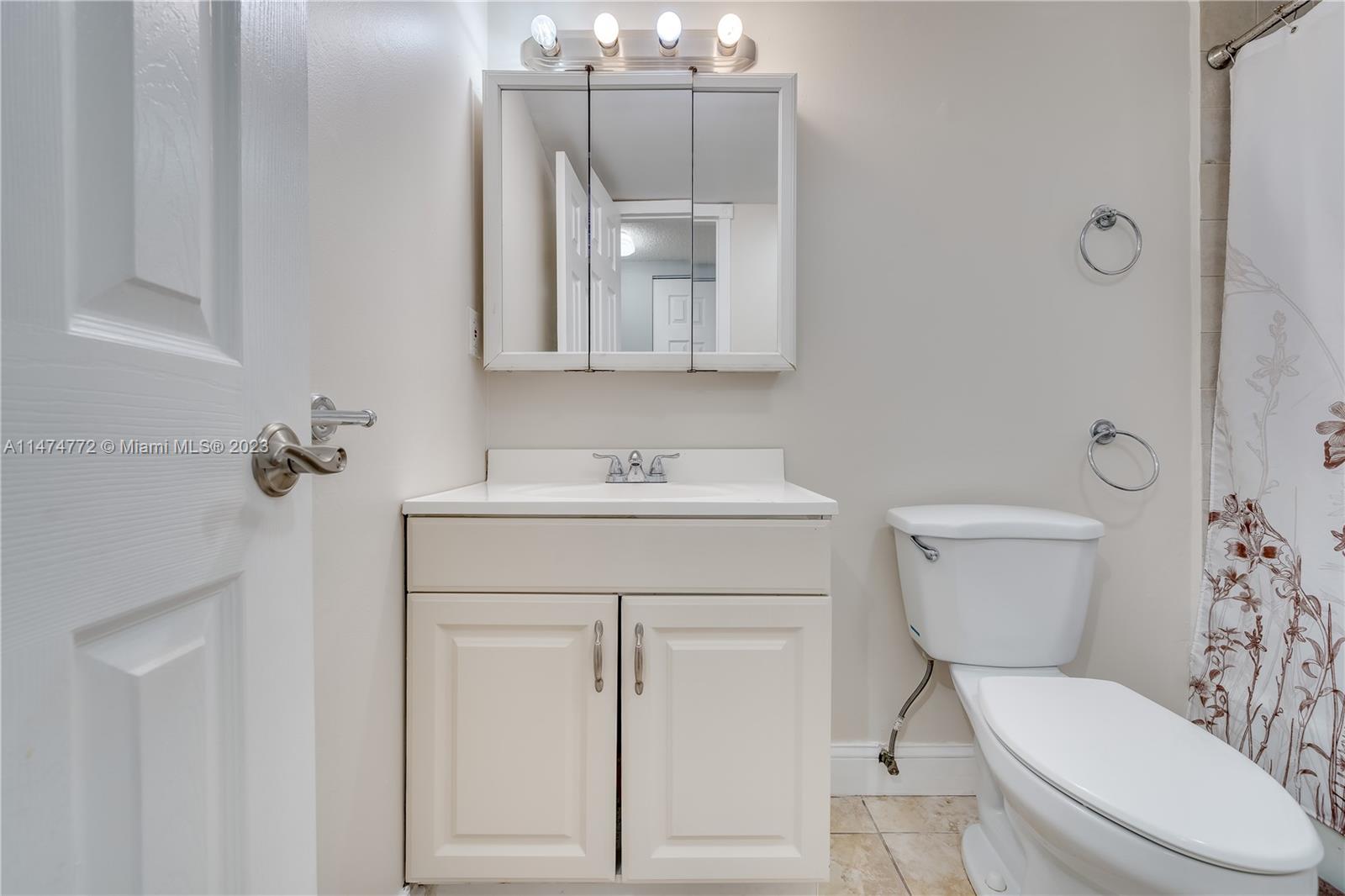 Promenade at Kendale Lakes Condominiums Miami, FL 33186 - Photo 20 of 29 a bathroom with a toilet a sink and mirror
