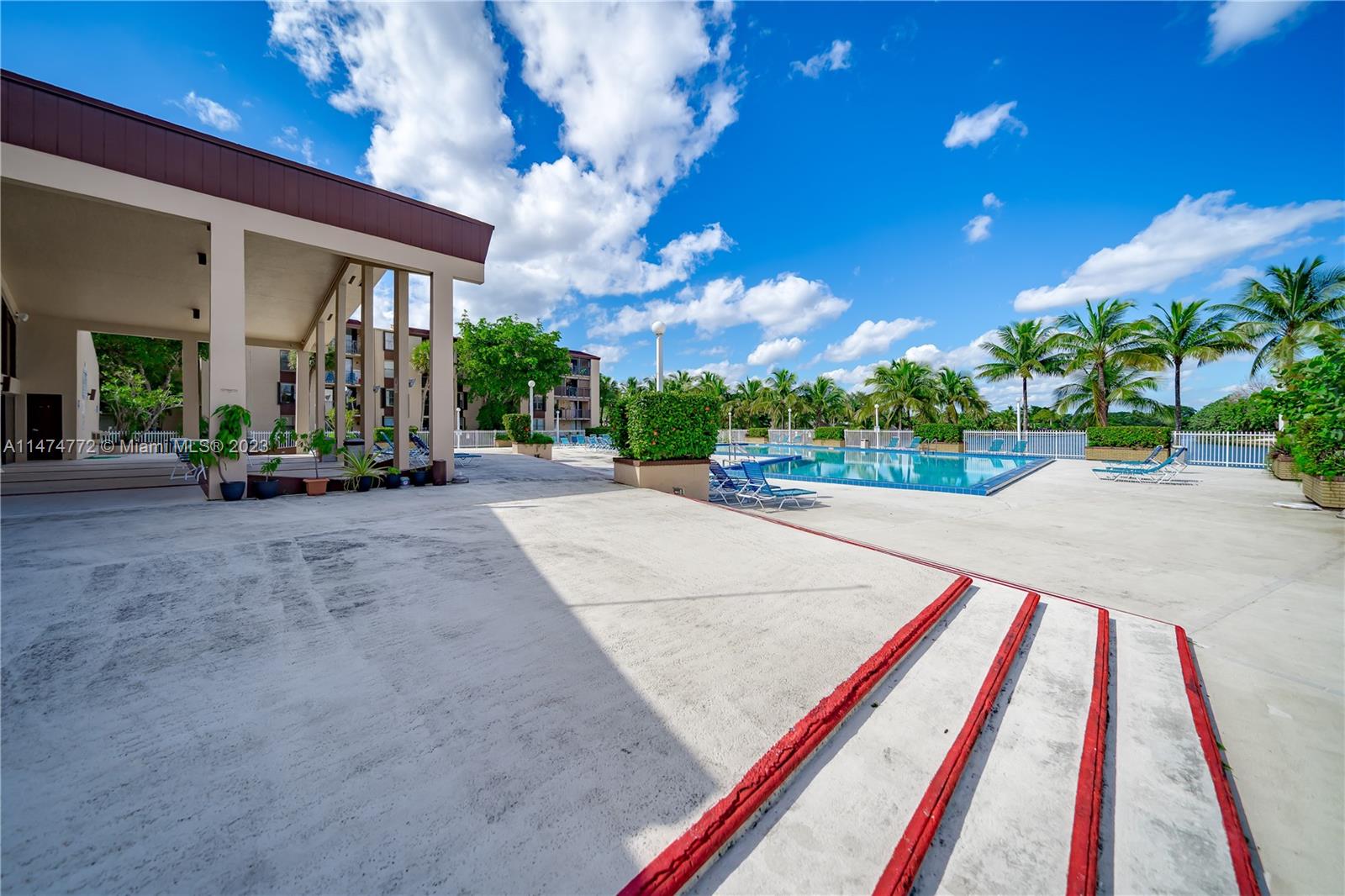 Promenade at Kendale Lakes Condominiums Miami, FL 33186 - Photo 22 of 29 a wooden bench sitting in front of a building