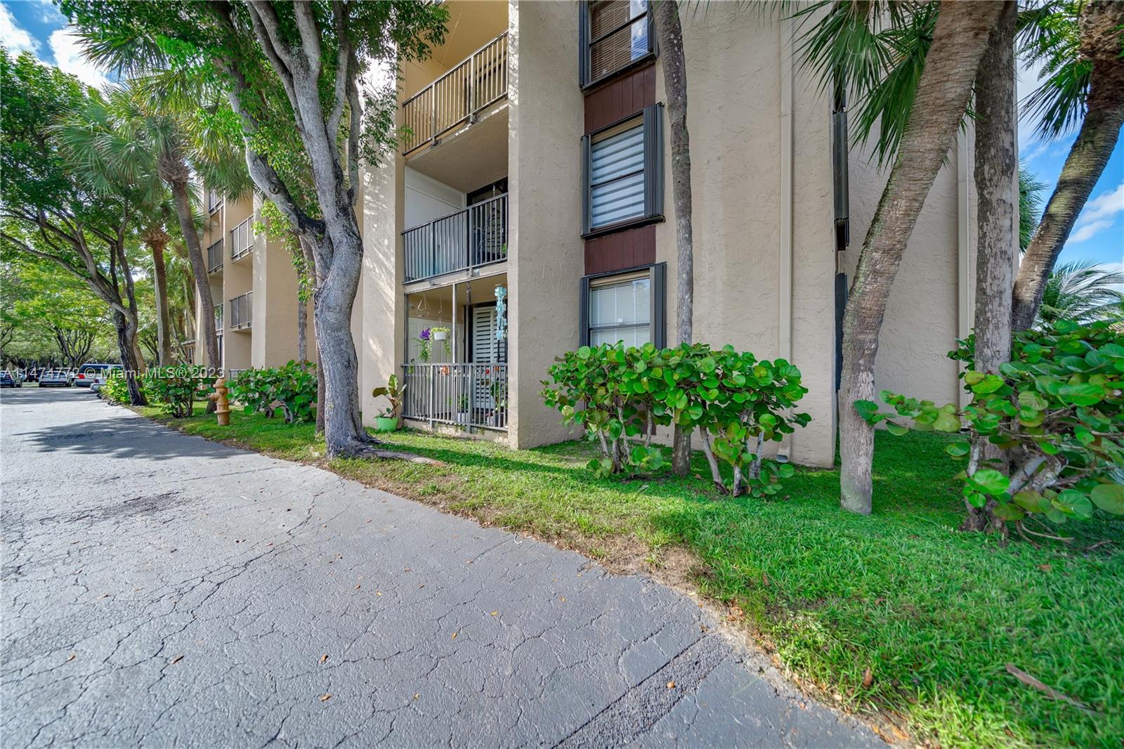 Promenade at Kendale Lakes Condominiums Miami, FL 33186 - Photo 25 of 29 a view of a brick house with a yard and large trees