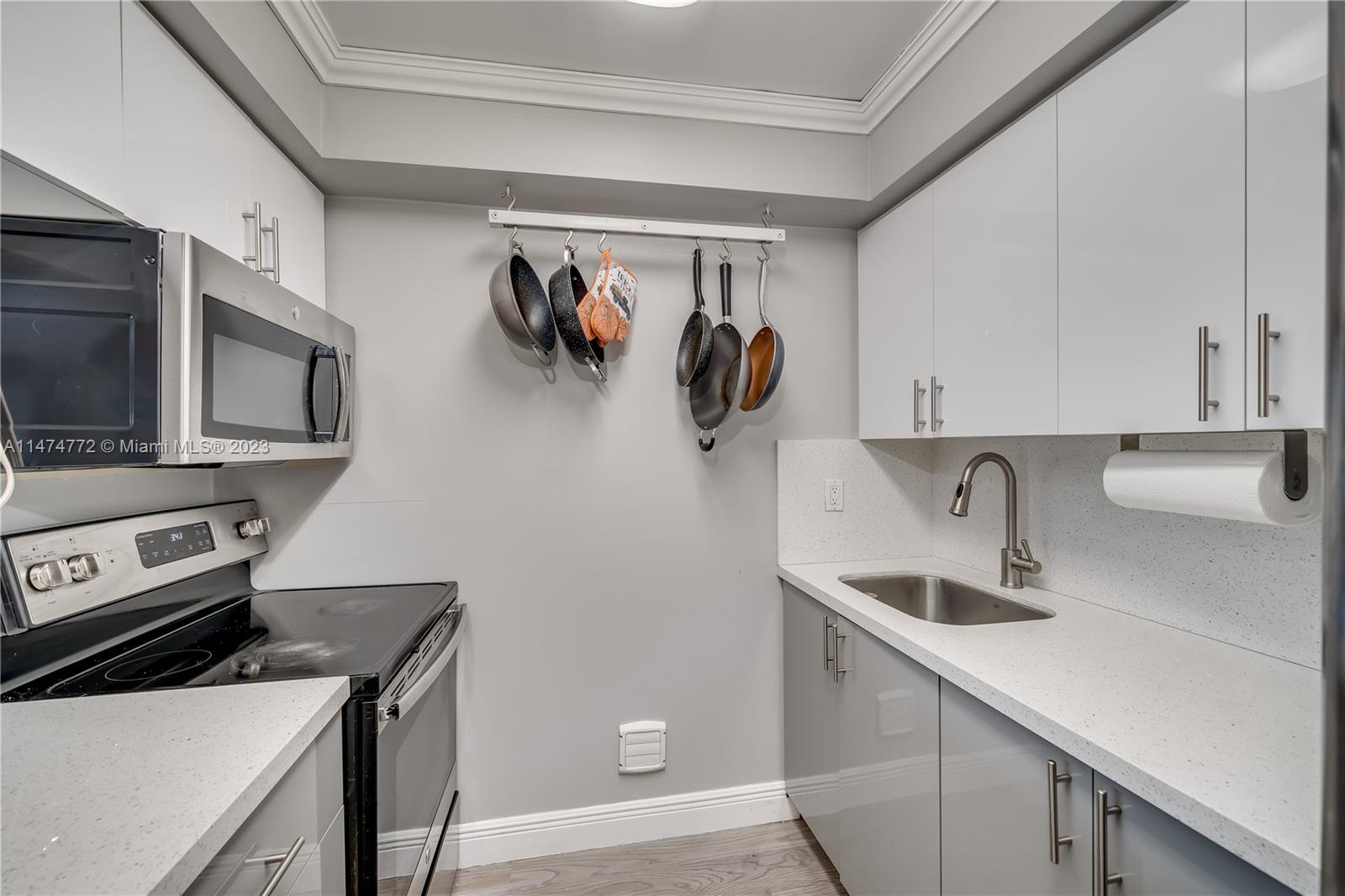 Promenade at Kendale Lakes Condominiums Miami, FL 33186 - Photo 4 of 29 a kitchen with a sink and a stove top oven