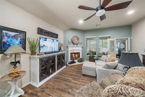 a living room with furniture a fireplace and a ceiling fan
