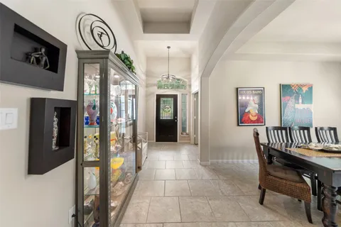 a dining room with furniture a chandelier and window