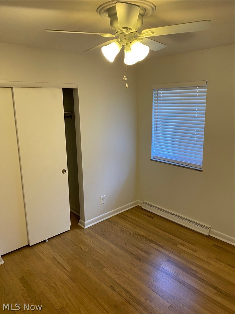 597 Baldwin Road Akron, OH 44312 - Photo 8 of 17 Unfurnished bedroom with a baseboard radiator, wood-type flooring, and ceiling fan