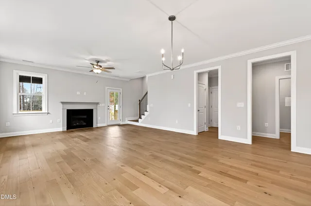 an empty room with windows and ceiling fan