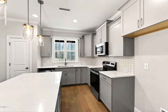 a kitchen with stainless steel appliances a sink stove and microwave